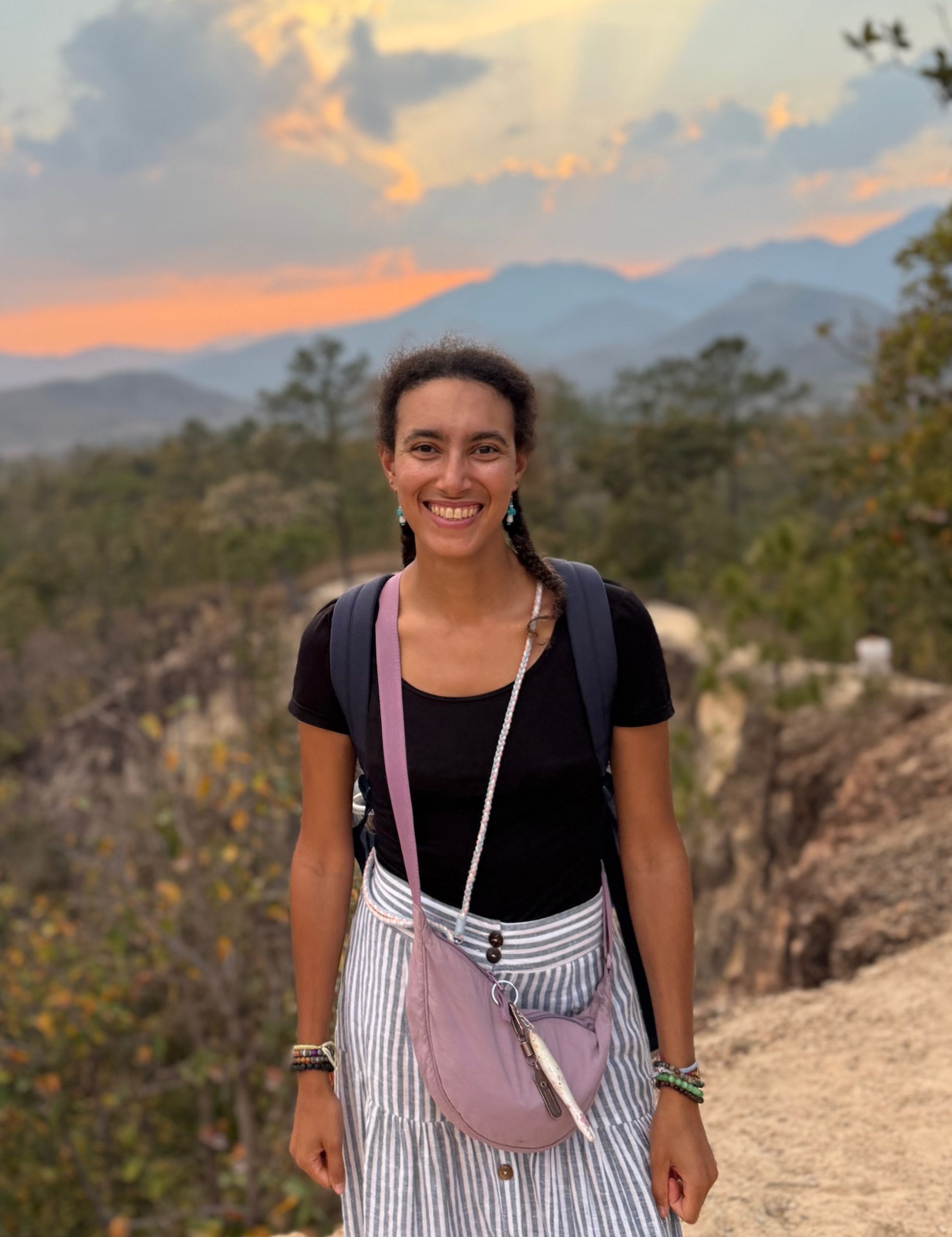 Juju, founder of Gentle Root Studio, standing outdoors at sunset