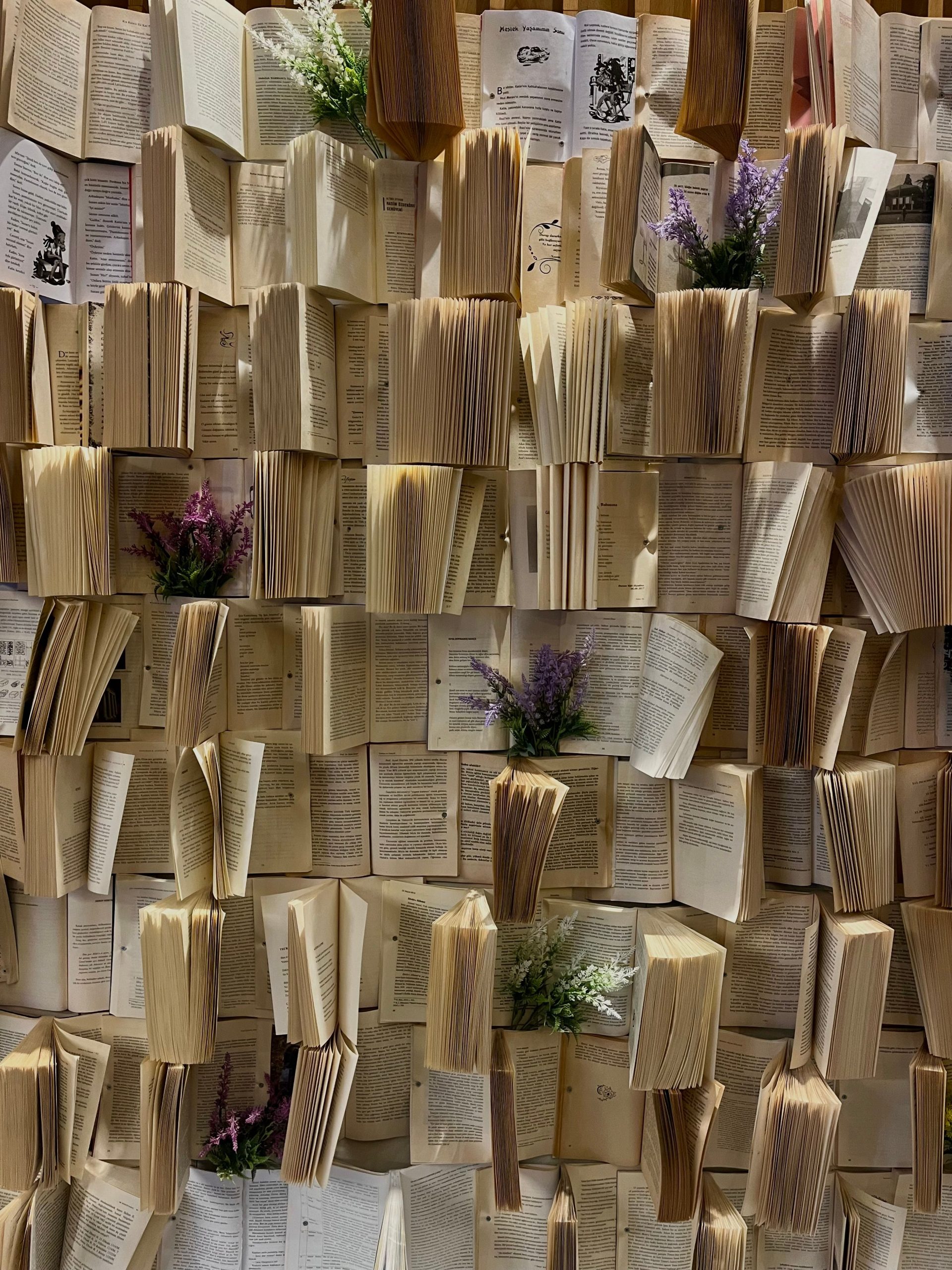 Wall of folded book pages decorated with small flower sprigs