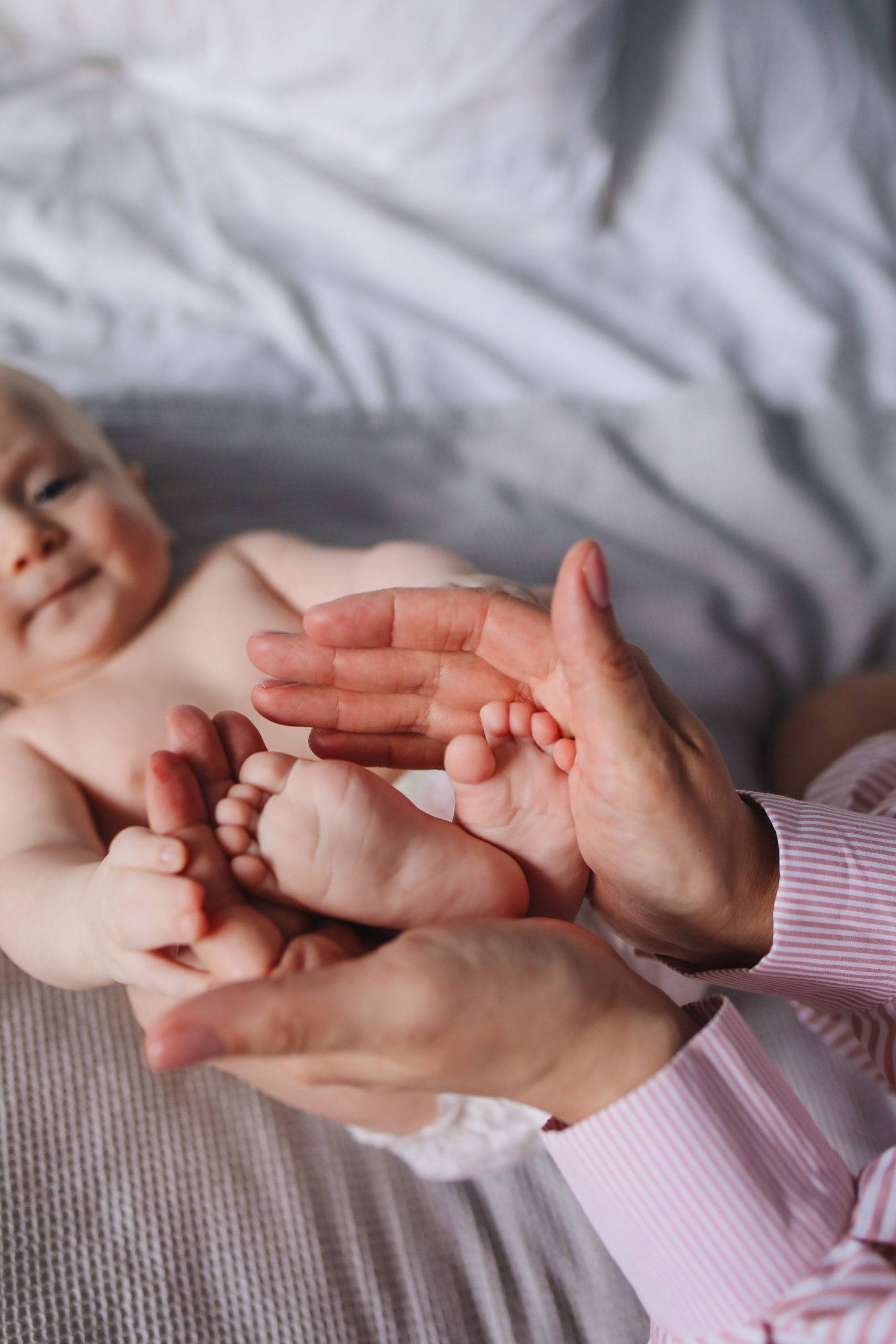Adult hands gently cupping a baby's feet